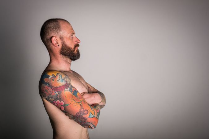 Young bearded guy with tattoos on hand