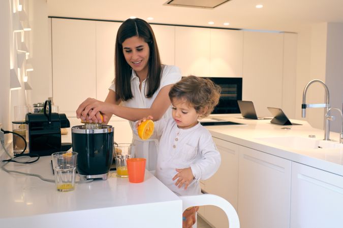 Mother and son preparing juice in kitchen