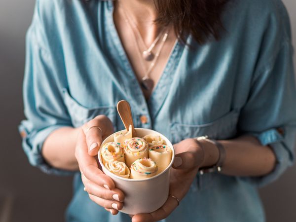 Hand holding rolled ice cream in cone cup