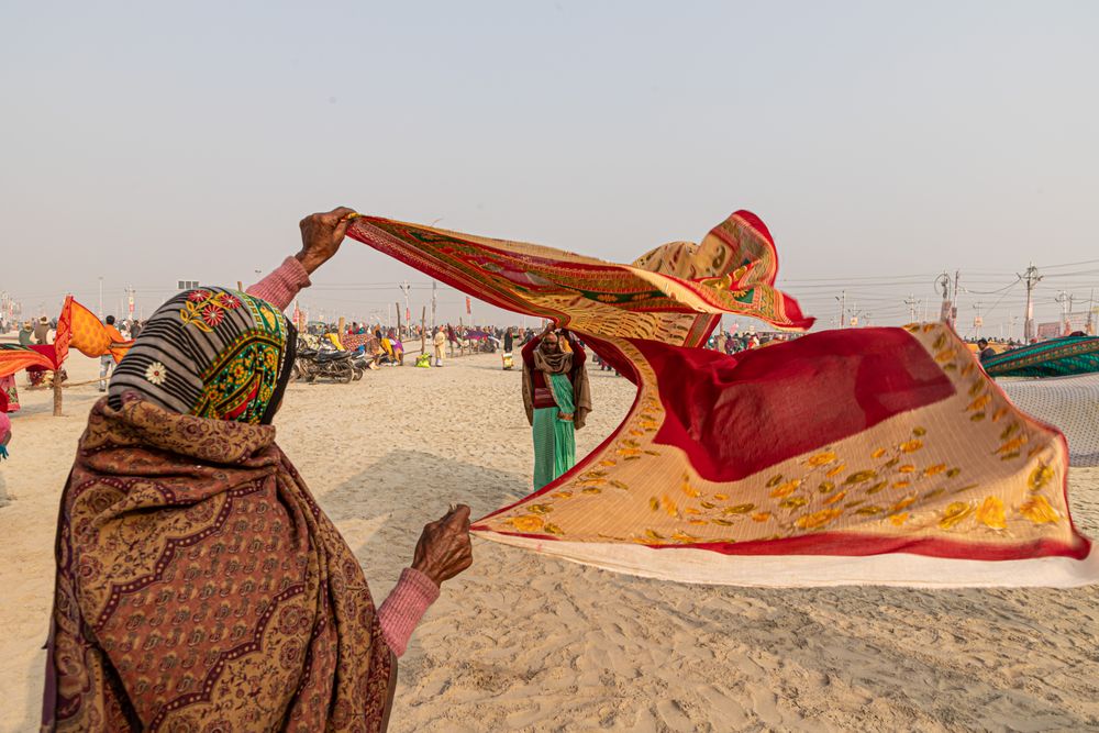 Back view of Indian woman waving colorful textile outdoor