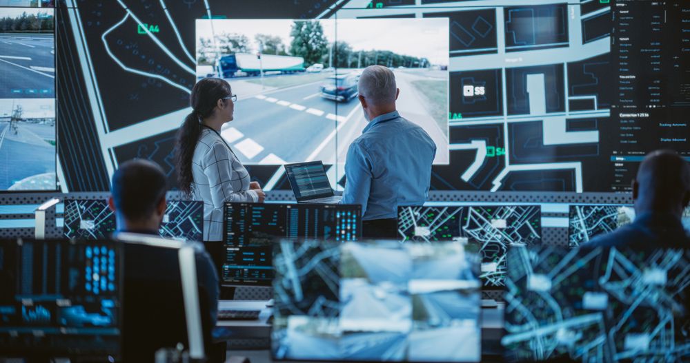 Diverse Team of Specialists Analyze Surveillance Feeds, Monitor Targets on a GPS City Map, Ensure Efficient Traffic Operations.