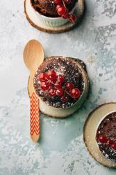 Three Chocolate cakes in the cup with currants and sugar glass.