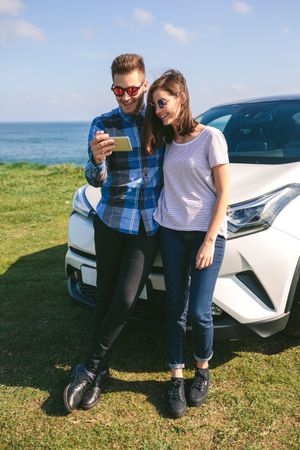 Couple with car looking mobile
