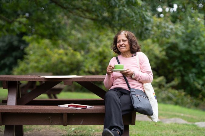 Mature woman sitting outside sipping tea