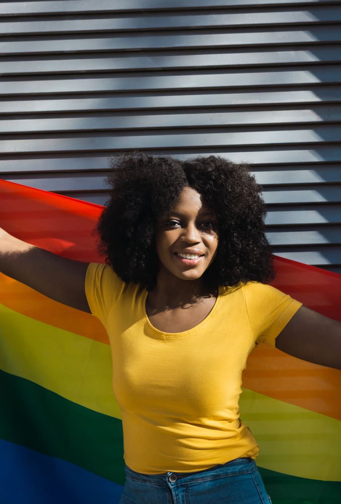 Woman posing happily with the LGBT flag