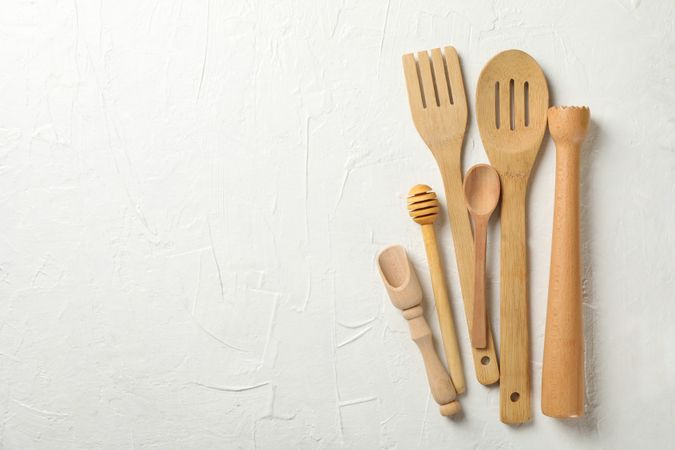 Wooden kitchen cutlery on blank background, space for text