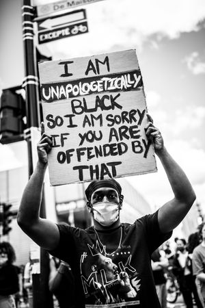 MONTREAL, QUEBEC, CANADA – June 7 2020- Black man holding a sign at an anti-racist protest