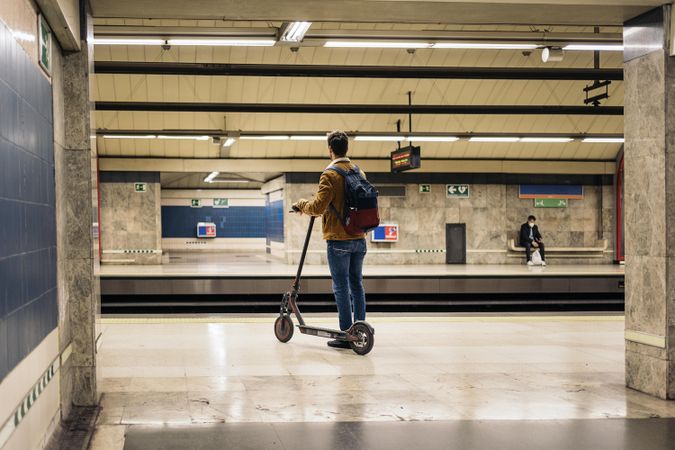 Man riding scooter in subway