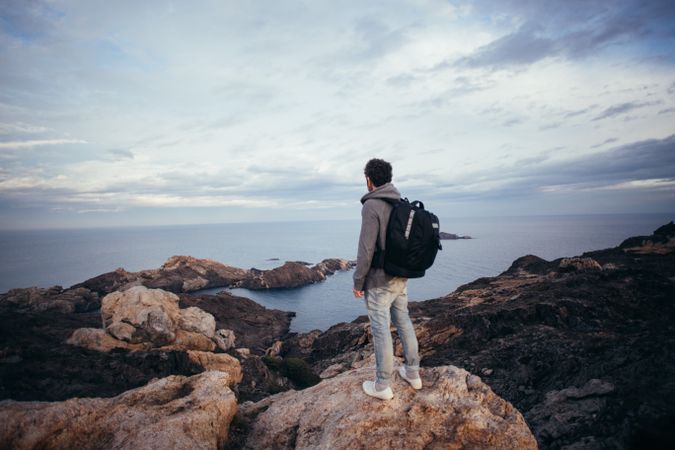 Solo trekker on the coast looking over the sea