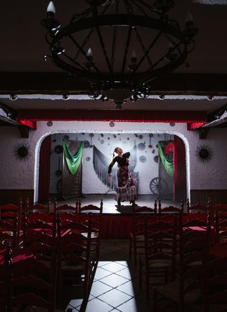 Woman dancer in flamenco costume standing in dance posture