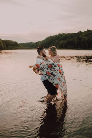 Loving couple standing ankle deep in water on beach