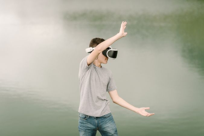 Young teenager with virtual reality glasses outdoors