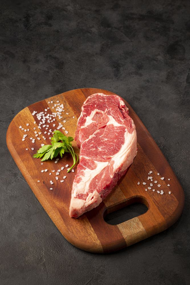 Raw ancho meat ready to roast on a wooden cutting board.