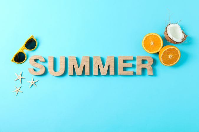 Inscription summer with starfishes, oranges, coconut and sunglasses on color background, space for text. Happy holidays