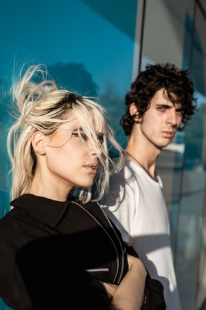 Charming sensual lady and calm guy against blue glossy wall