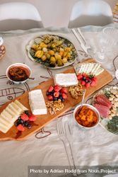 Cheese plate with berries and walnuts on table with olives and cured meats 5n8dQb