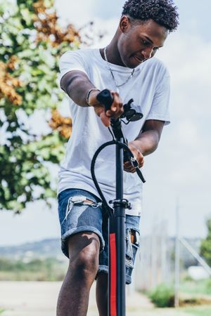 Black man riding on electric scooter in park