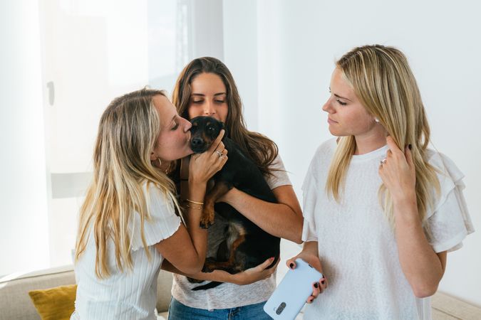 Smiling girlfriends with cute dog