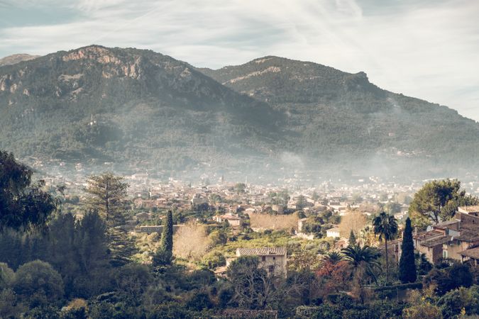 Picturesque scenery of town against forested mountains