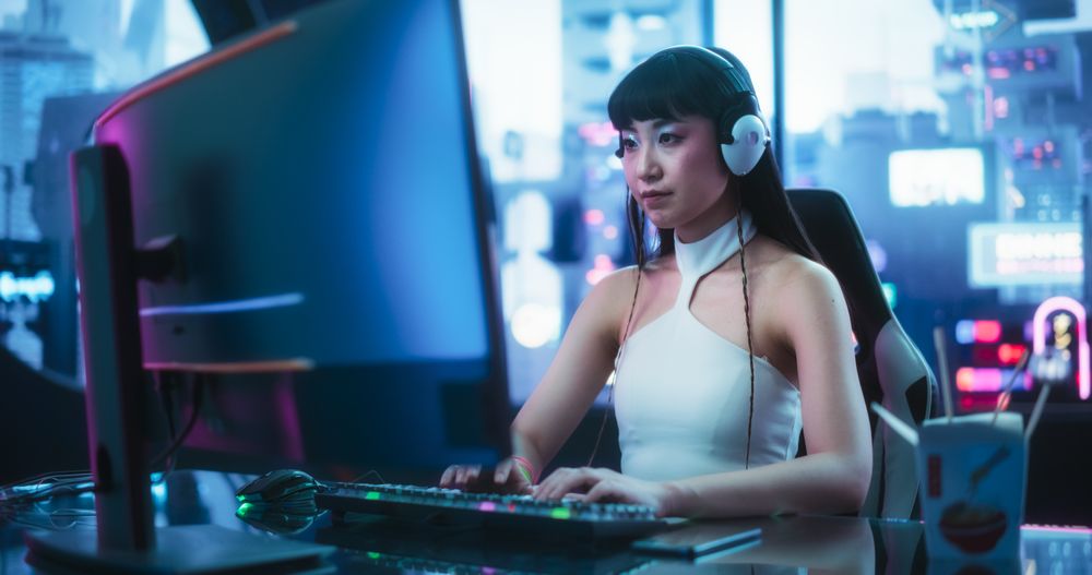 Creative Japanese Female Using Desktop Computer in a Futuristic High Tech Office Space.