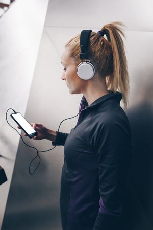 Woman with sportswear listening to music with headphones