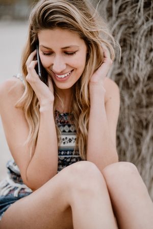 female talking on smartphone on beach