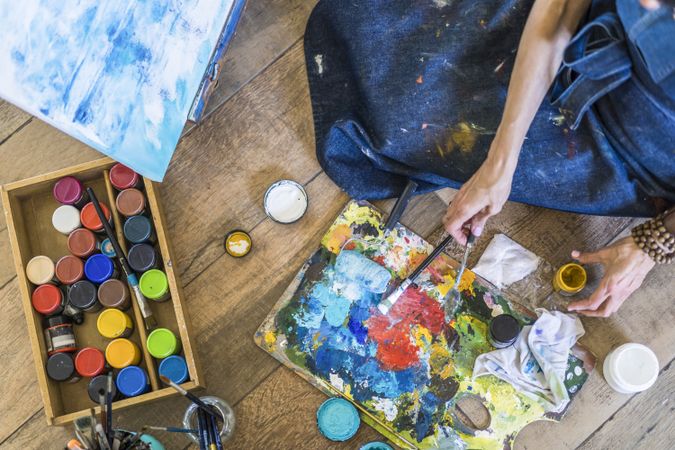 High angle view of brushes, pallete, oils, acrylics and other elements of a painter artist. Art workshop. Background.