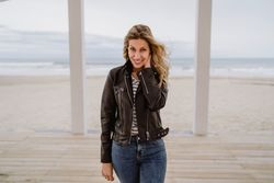 Woman on white wooden pier with ocean on background