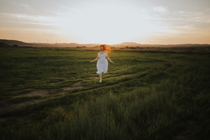 Anonymous woman walking in flower field