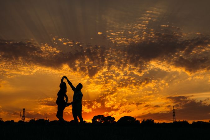 Anonymous couple dancing during sunset