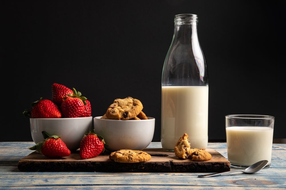 Glasses near fruits and cookies on table near napkin