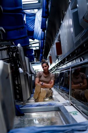 Military woman looking up inside vehicle