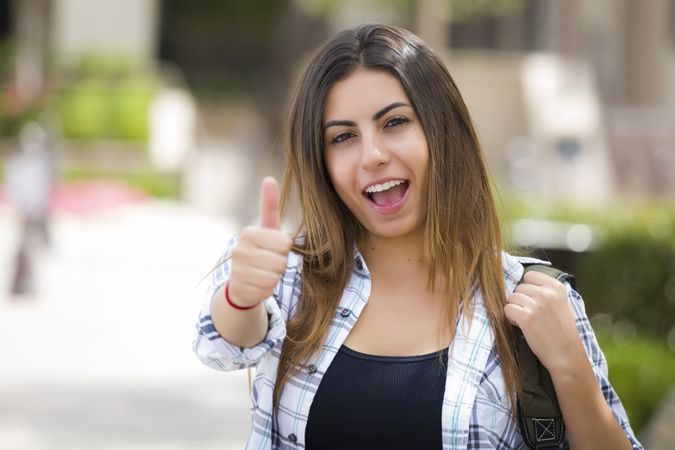 Female Student on School Campus with Thumbs Up