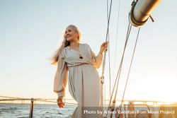 Older radiant woman in a dress on a sailboat at dusk 0ydMnb