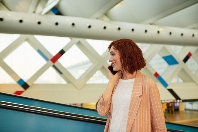 Smiling young woman browsing phone at station