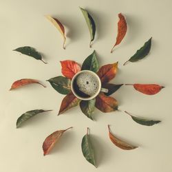 Autumn leaves and coffee cup on table