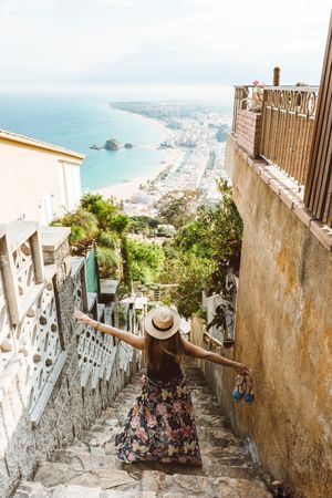 Stylish woman picturing coast from stairway