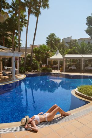 Faceless woman resting on edge of pool