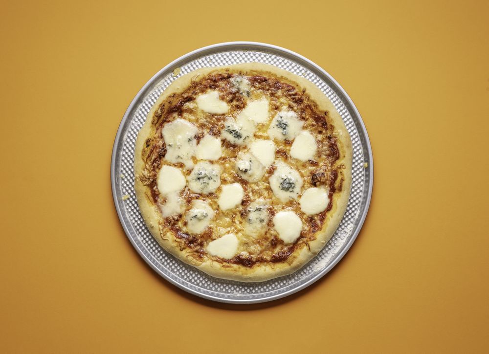Four cheese pizza on a baking tray