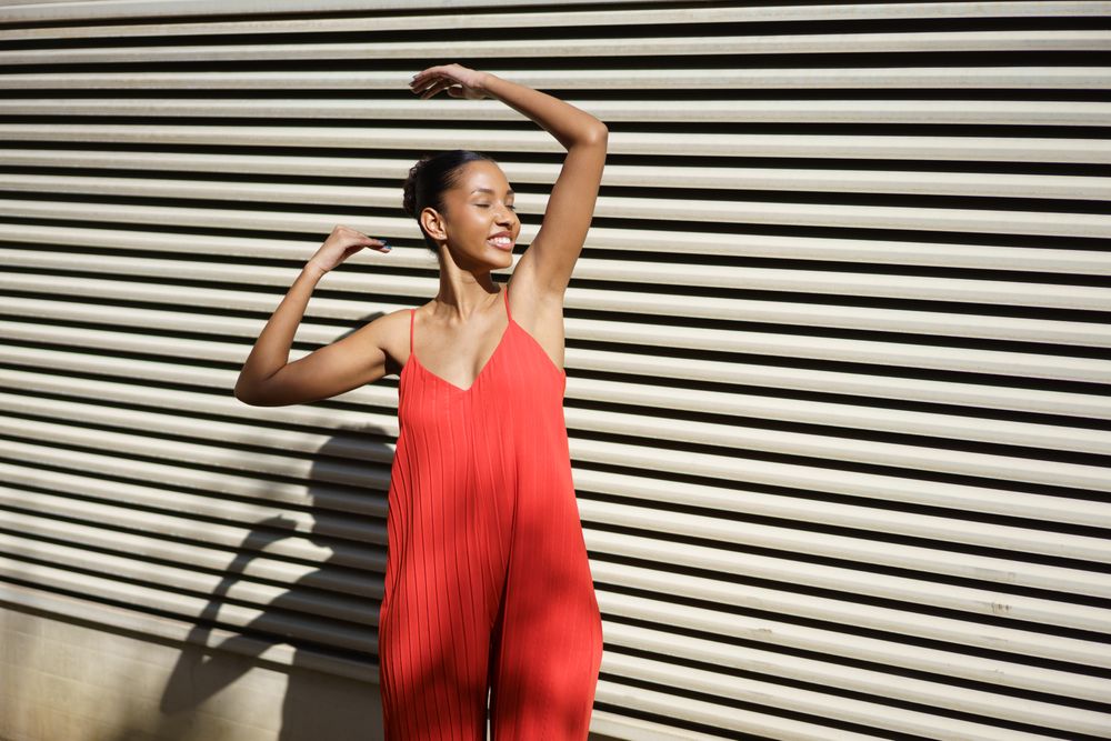 A Joyful Dance Painted in Bright Red Outfit, Set Against an EyeCatching Striped Background