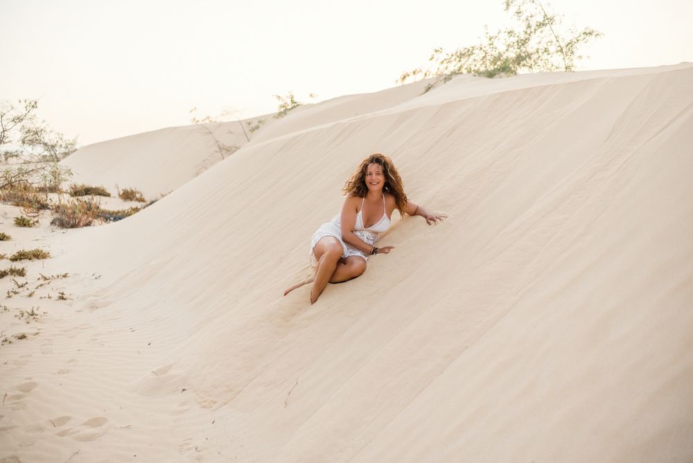 Woman sitting on sand in desert