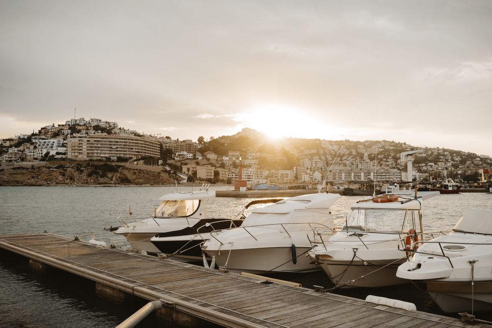 Yachts docked in sea port at sunset