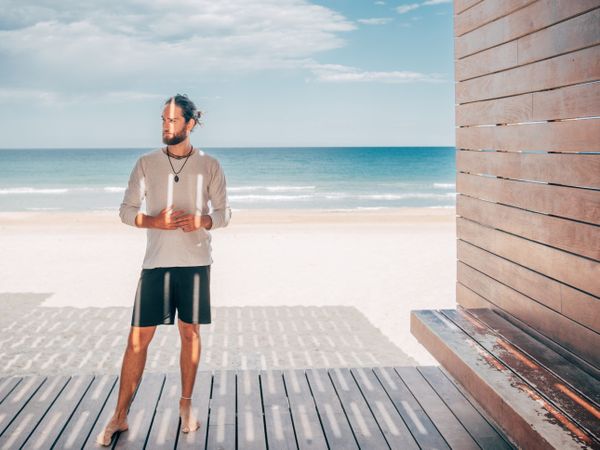 Man standing on wooden pier on the beach