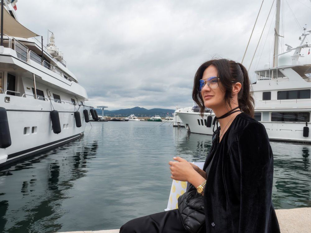 Woman in a sits near moored yachts
