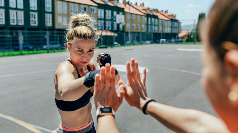 Sportswoman training boxing with her trainer