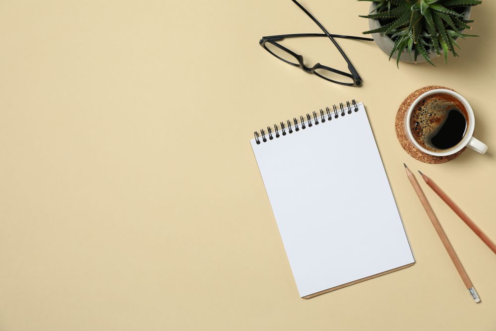 Office concept with blank notebook on beige background, space for text