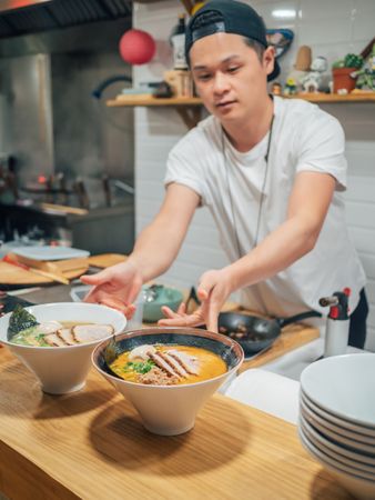 Asian chef with served bowls of ramen