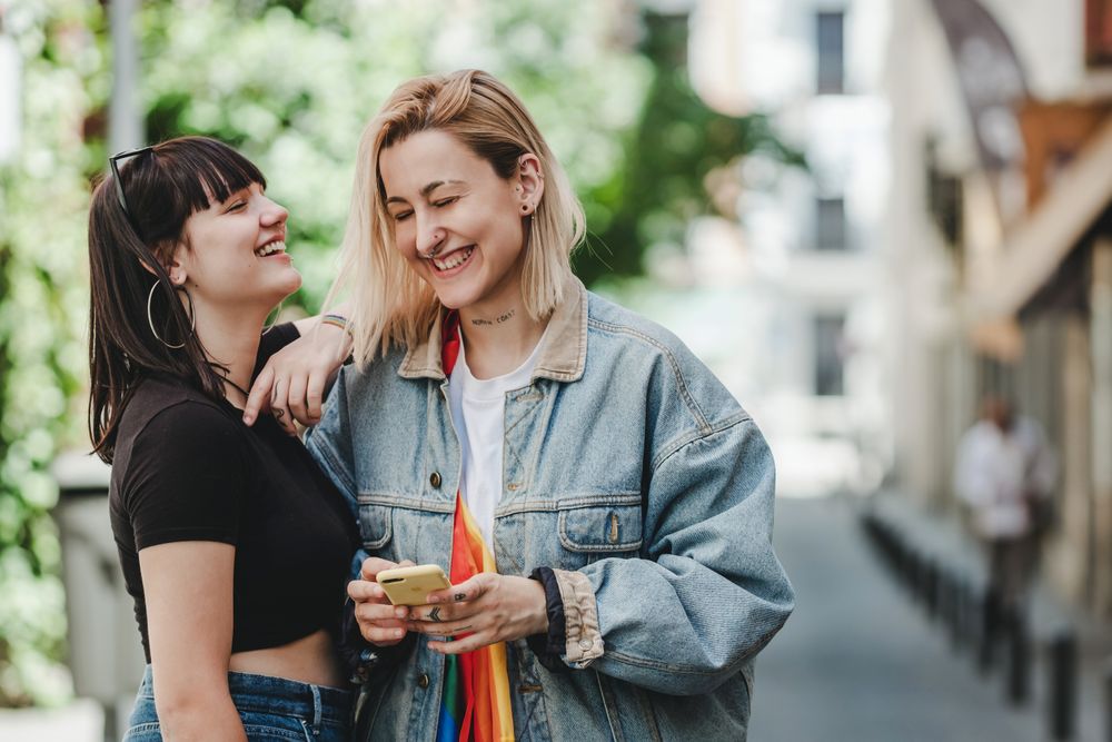Lesbian couple on the mobile phone on street