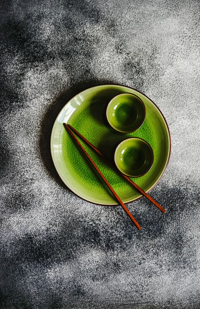 Green plate with chopsticks and cups