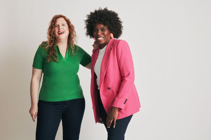 Two women smiling near each other in bright clothes
